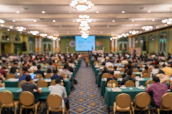 Abstract blurred photo of conference hall or seminar room with attendee background